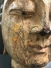 Une t&ecirc;te de Bouddha en pierre sculpt&eacute;e, traces de dorure et polychromie, Chine, Ming