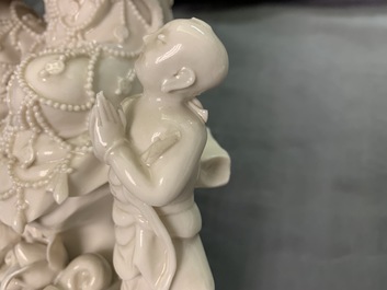 Twee Chinese Dehua blanc de Chine figuren van Guanyin met dienaar en een Luohan, 19e eeuw