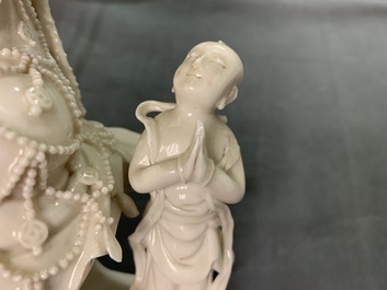 Twee Chinese Dehua blanc de Chine figuren van Guanyin met dienaar en een Luohan, 19e eeuw