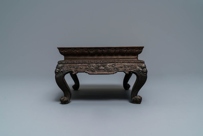 A Chinese carved wooden stand with famille rose plaque, 19th C.