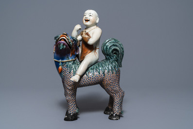 A Chinese famille rose figure of Buddha and a famille rose boy on qilin, 19th C.