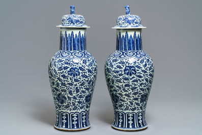 A pair of Chinese blue and white vases and covers with floral sprigs, 19th C.