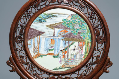 A Chinese carved wooden screen with a famille rose plaque, 19/20th C.