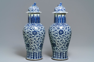 A pair of Chinese blue and white vases and covers with floral sprigs, 19th C.