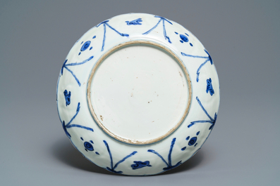 Une assiette en porcelaine de Chine bleu et blanc de type kraak &agrave; d&eacute;cor de chevaux, Wanli
