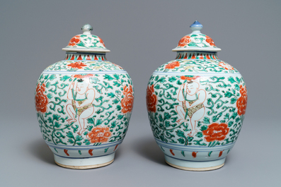 A pair of Chinese wucai vases and covers with boys among peonies, Transitional period