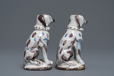 A pair of blue, white and manganese Brussels faience models of dogs, 18th C.