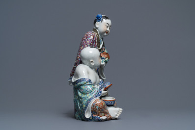 A Chinese famille rose group of two children, impressed marks, Republic, 20th C.