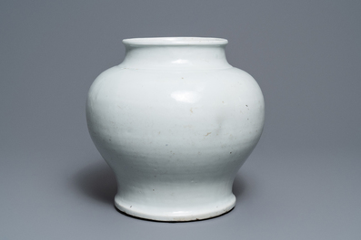 A Chinese monochrome white vase with a wooden cover and stand, Ming