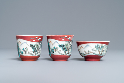 A Chinese famille rose ruby-ground teapot, three cups and two saucers, Yongzheng