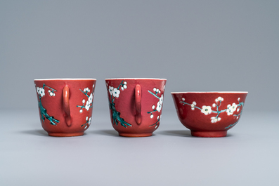 A Chinese famille rose ruby-ground teapot, three cups and two saucers, Yongzheng