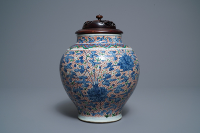 A Chinese wucai 'lotus scroll' jar with wooden cover and stand, Transitional period