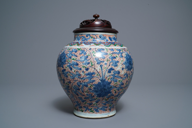 A Chinese wucai 'lotus scroll' jar with wooden cover and stand, Transitional period