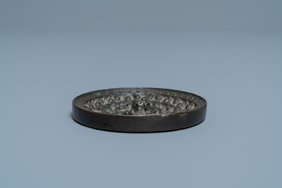 Een Chinese bronzen spiegel met reli&euml;fdecor, Tang