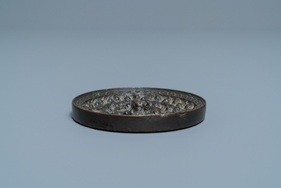 A Chinese bronze mirror with relief design, Tang