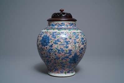 A Chinese wucai 'lotus scroll' jar with wooden cover and stand, Transitional period