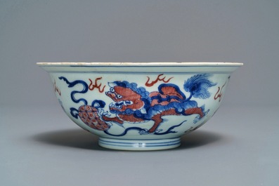 Een Chinese blauw-witte en onderglazuur rode kom met tempelleeuwen, Qianlong merk en periode