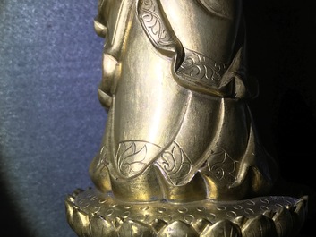 Een Chinese verguld bronzen figuur van een staande Boeddha met inscriptie, Qianlong