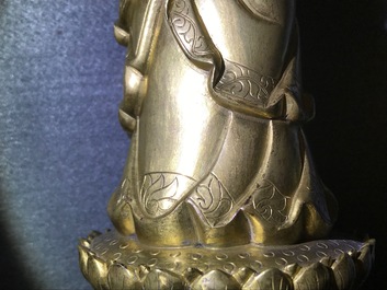 Een Chinese verguld bronzen figuur van een staande Boeddha met inscriptie, Qianlong