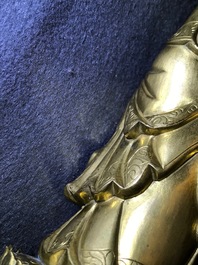 Een Chinese verguld bronzen figuur van een staande Boeddha met inscriptie, Qianlong