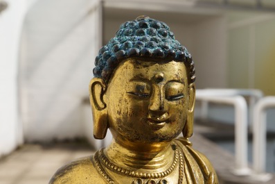 Een Chinese verguld bronzen figuur van een staande Boeddha met inscriptie, Qianlong