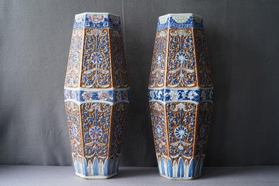 Une paire de vases de forme hexagonale en porcelaine de Chine bleu, blanc et rouge sur fond brun, 19&egrave;me