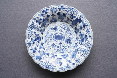 Two Chinese blue and white gadrooned 'crabs and carps' dishes and a pair of plates, Kangxi