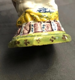 A rare polychrome Dutch Delft caster in the shape of a pooping man, 18th C.