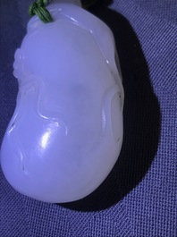 Un pendentif en jade blanc figurant un singe sur une pochette, Qing