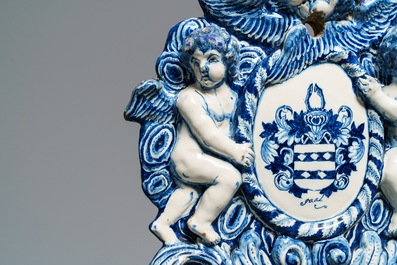 A large Dutch Delft blue and white armorial relief-decorated plaque, early 18th C.