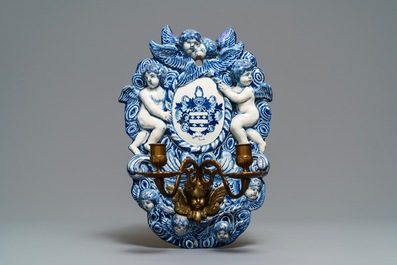 A large Dutch Delft blue and white armorial relief-decorated plaque, early 18th C.