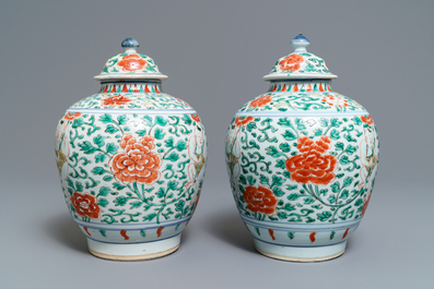 A pair of Chinese wucai vases and covers with boys among peonies, Transitional period