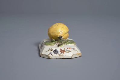 A polychrome Dutch Delft model of a lemon on a base, ca. 1800