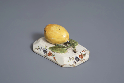 A polychrome Dutch Delft model of a lemon on a base, ca. 1800