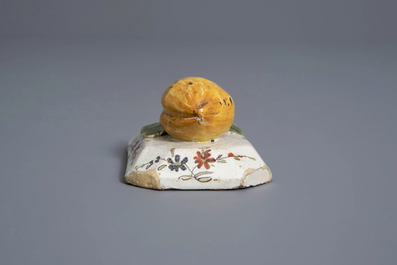 A polychrome Dutch Delft model of a lemon on a base, ca. 1800