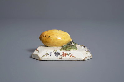 A polychrome Dutch Delft model of a lemon on a base, ca. 1800