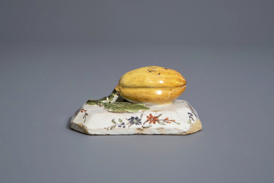 A polychrome Dutch Delft model of a lemon on a base, ca. 1800