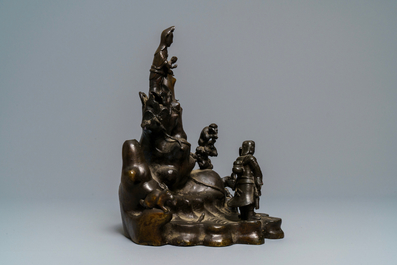 Een grote Chinese bronzen groep met Guanyin met kind op een rots, Ming