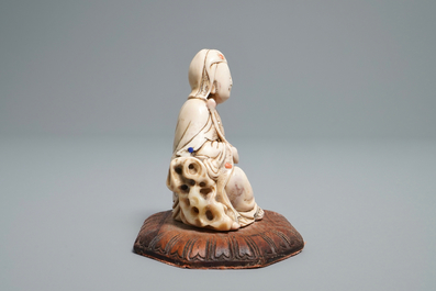 A Chinese inlaid soapstone figure of a seated deity, 17/18th C.