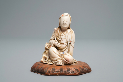 A Chinese inlaid soapstone figure of a seated deity, 17/18th C.