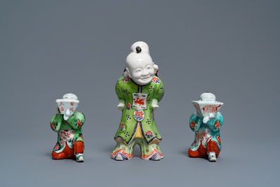 A pair of Chinese blue and white candlesticks and three famille rose figures of boys, 19th C.