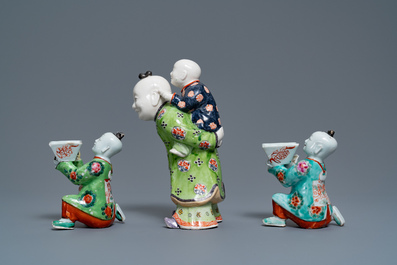 Een paar Chinese blauw-witte kandelaars en drie famille rose figuren van jongens, 19e eeuw