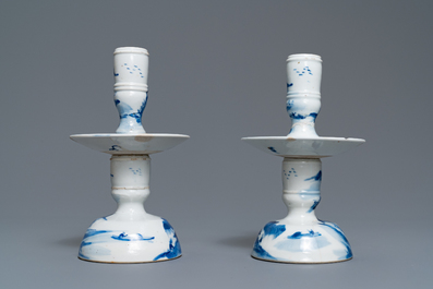 A pair of Chinese blue and white candlesticks and three famille rose figures of boys, 19th C.