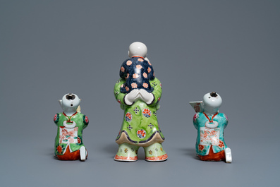 Een paar Chinese blauw-witte kandelaars en drie famille rose figuren van jongens, 19e eeuw