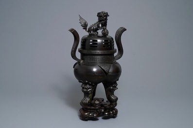A large Chinese bronze incense burner and cover on carved wooden stand, Ming