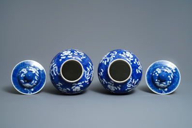 A pair of Chinese blue and white 'prunus on cracked ice' vases and covers, 19th C.