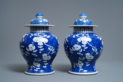 A pair of Chinese blue and white 'prunus on cracked ice' vases and covers, 19th C.