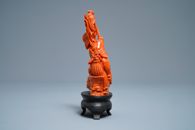 A Chinese carved red coral group of a boy with a parrot, 19/20th C.