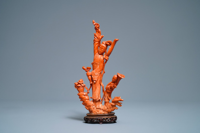 A Chinese carved red coral group of a lady and child, 19th C.