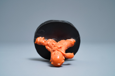 A Chinese carved red coral group of a boy with a dog, 20th C.